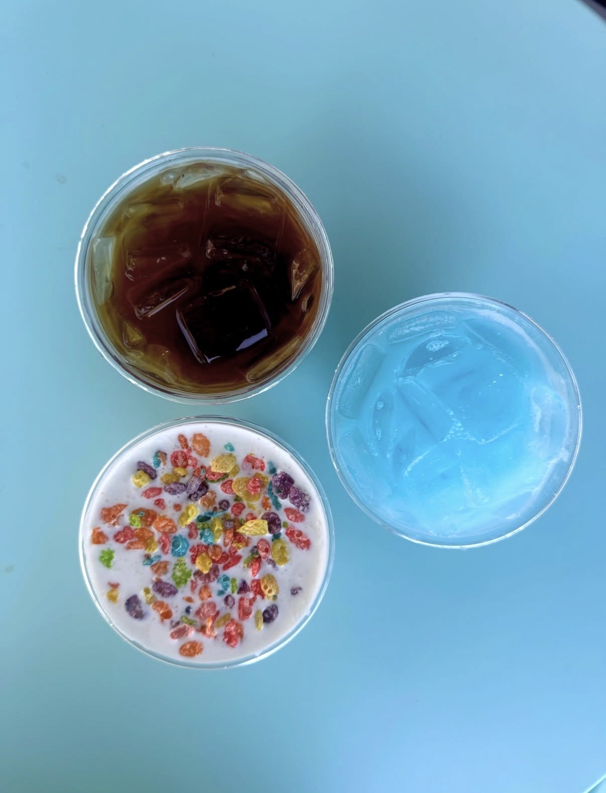 Top-down view of three Tiki Bean drinks on a bright blue table